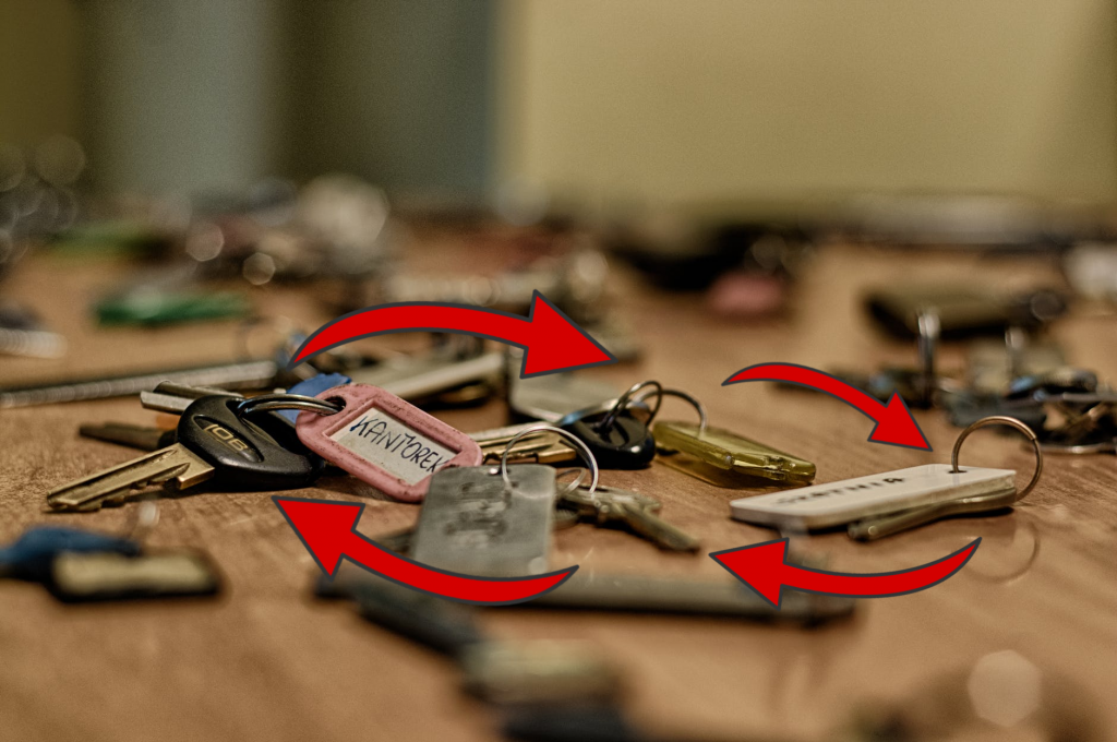 Dozens of sets of keys on a table with red arrows connecting them.