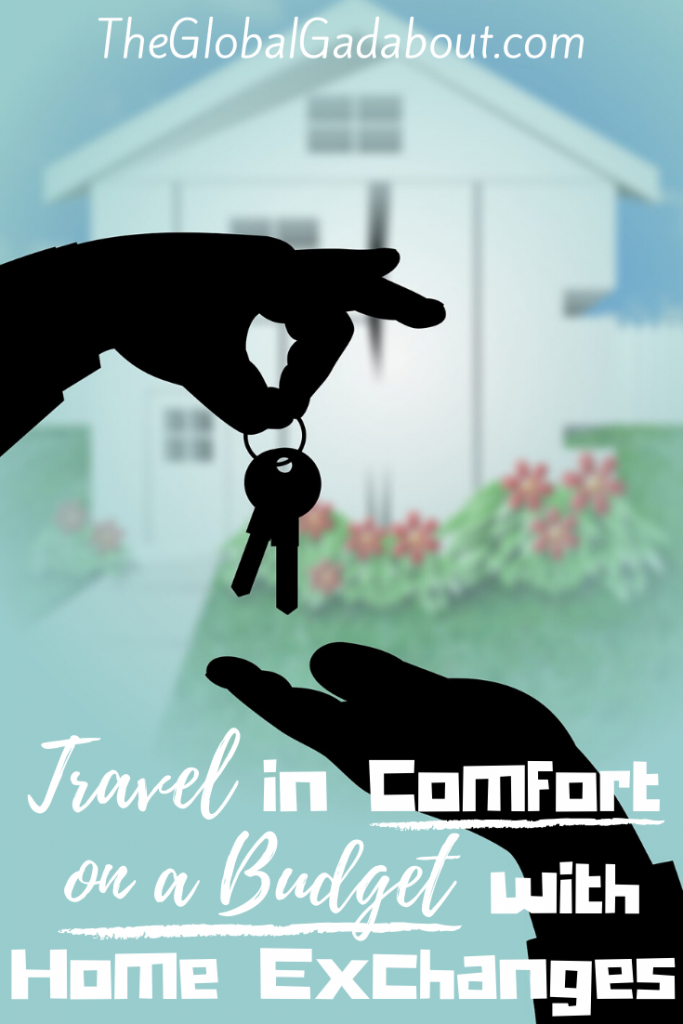 The graphic of a house & yard out of focus in the background. Black silhouettes of a hand dropping keys into another hand in the foreground. White words read "TheGlobalGadabout.com" across the top and "Travel in Comfort on a Budget with Home Exchanges" across the bottom.