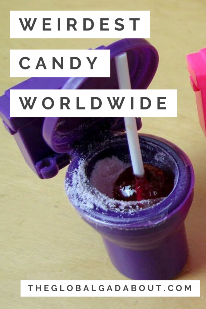 Purple plastic toilet bowl with sour powder and a lollipop plunger in the bowl. White overlay rectangles with the words "Weirdest Candy Worldwide" and "TheGlobalGadabout.com"