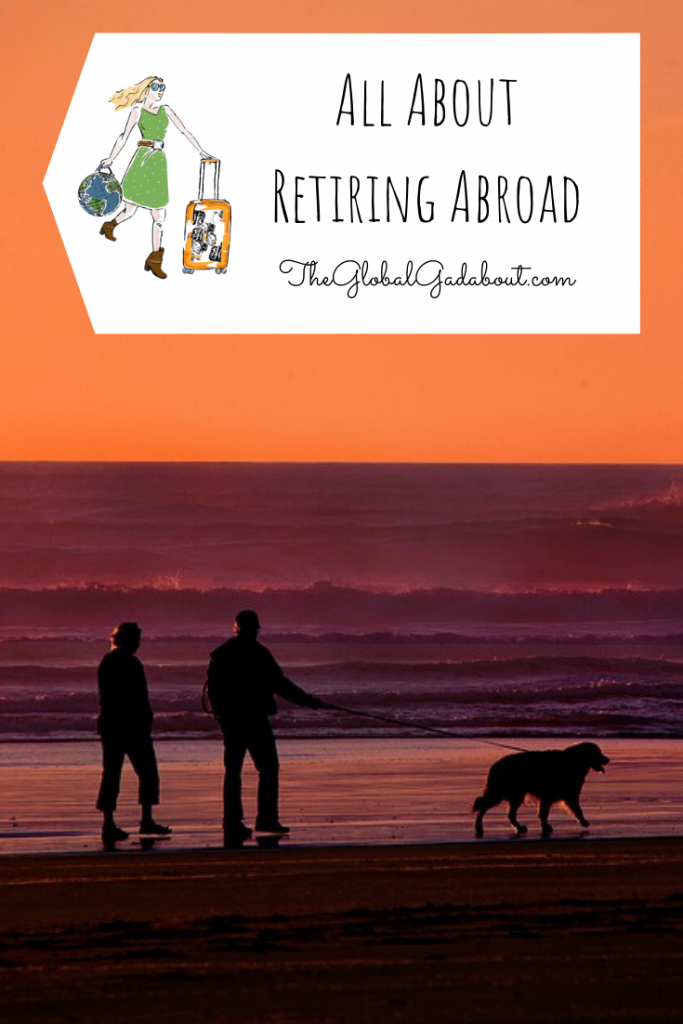 An older couple walking a dog along a beach at sunset. A white luggage-tag shape in the top third with The Global Gadabout logo and the words "All About Retiring Abroad" and "TheGlobalGadabout.com".