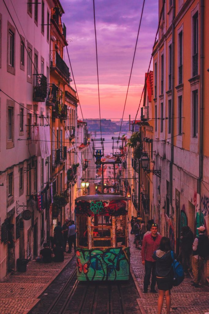 City street in Portugal at sunset with a tram.