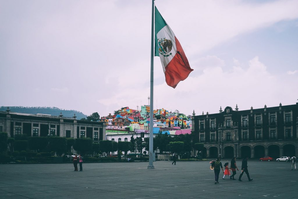 Mexican city square with a large flag in the middle.