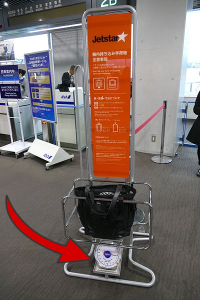 A size-guide for carry-on luggage for Jet star airlines. A red arrow points to the scale underneath the sizer.