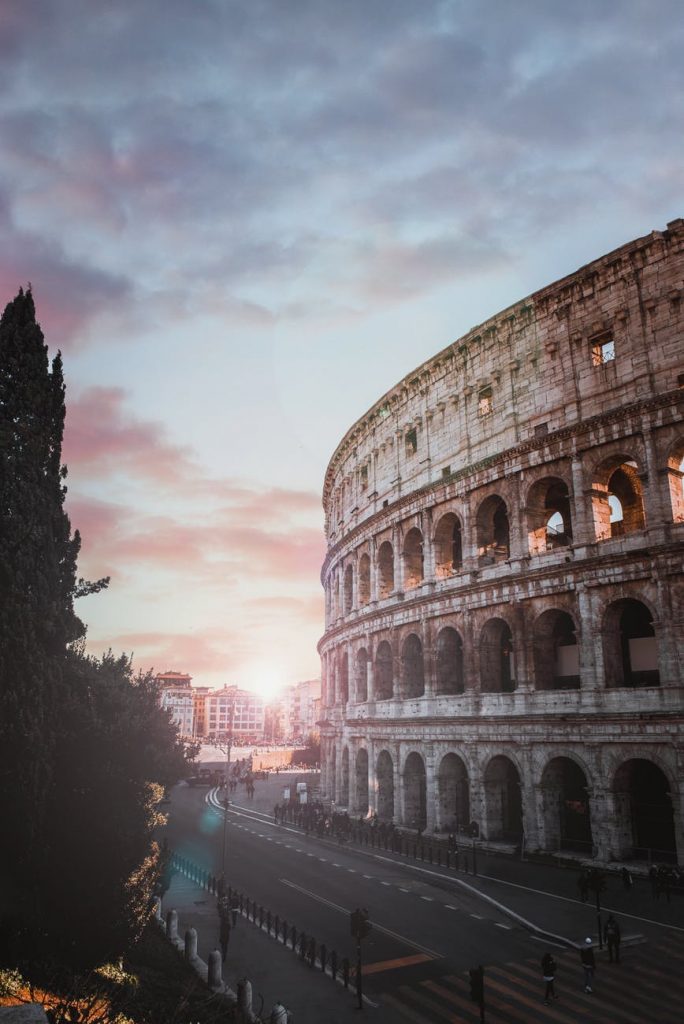 The Colosseum and an empty Roman street at sunset.