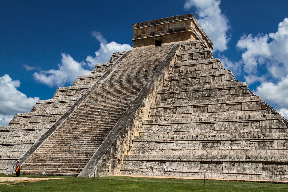 El Castillo step-pyramid at Chichen Itza in Mexico with a blue sky behind.