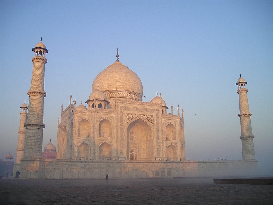 The Taj Mahal at dusk or dawn with a clear blue sky behind.