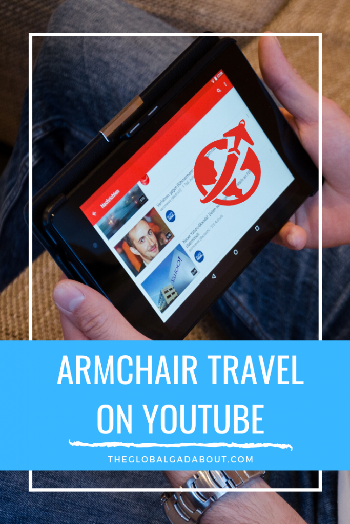 Seated person holding a tablet with YouTube and a travel icon on the screen. Only the person's hands and legs are showing. A blue box at the bottom has the words "Armchair Travel on YouTube" and "TheGlobalGadabout.com" in white.