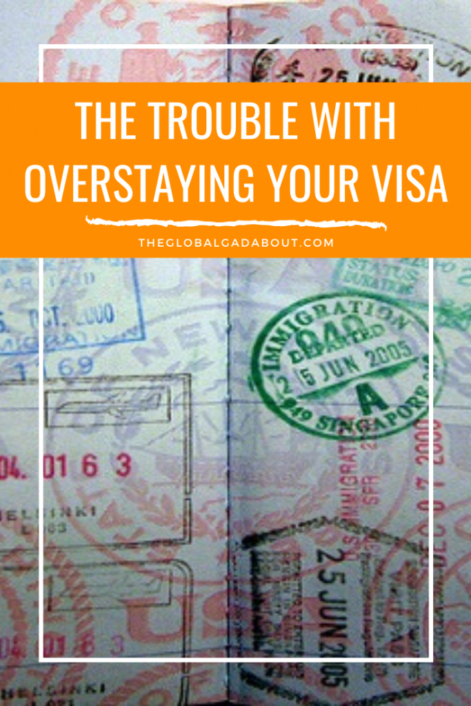 A visa page from a passport with lots of stamps. An orange box covers the top with the words, "The Trouble With Overstaying Your Visa" and "TheGlobalGadabout.com" in white.