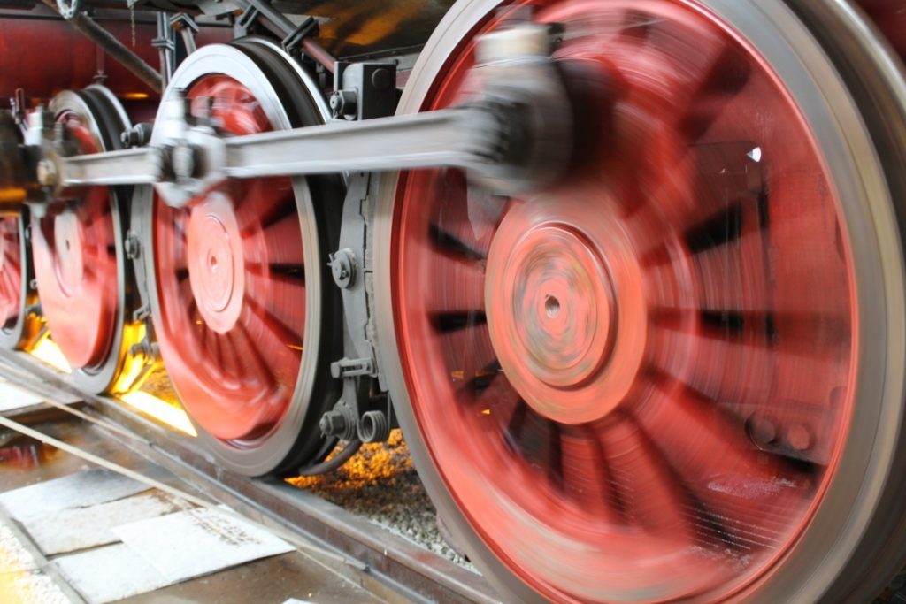 Close-up on train wheels blurred by motion.