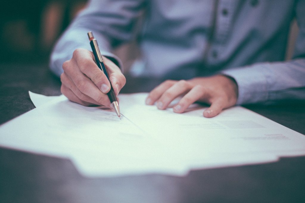 Close up of hands filling out paperwork.